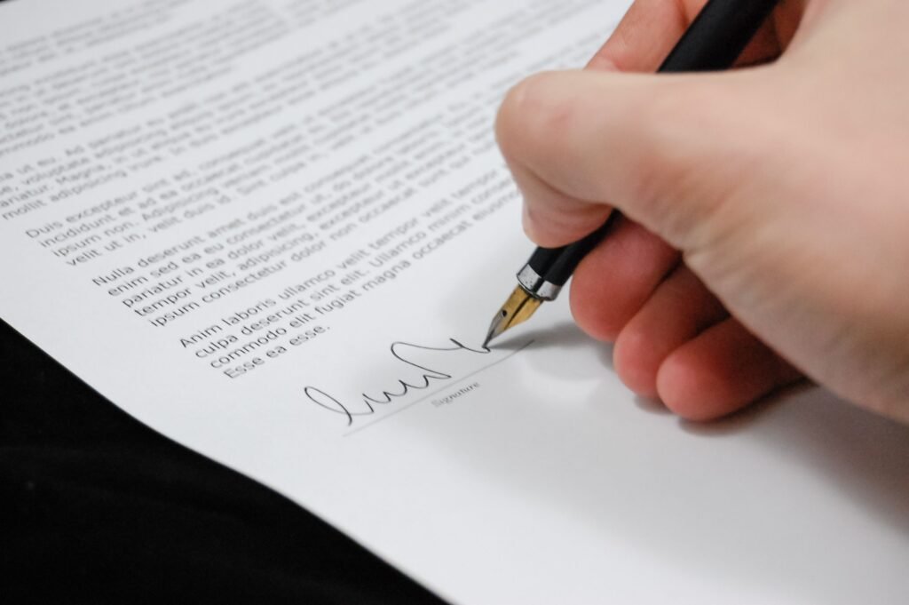 Wie erstelle ich aus Deutschland eine Vollmacht für die Türkei? Close-up of a hand signing a legal document with a fountain pen, symbolizing signature and agreement.